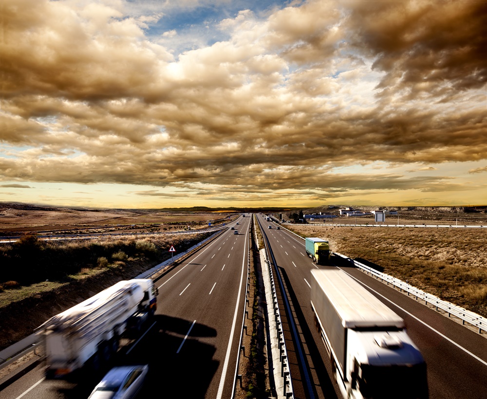caminhões e carros e uma estada bem movimentada